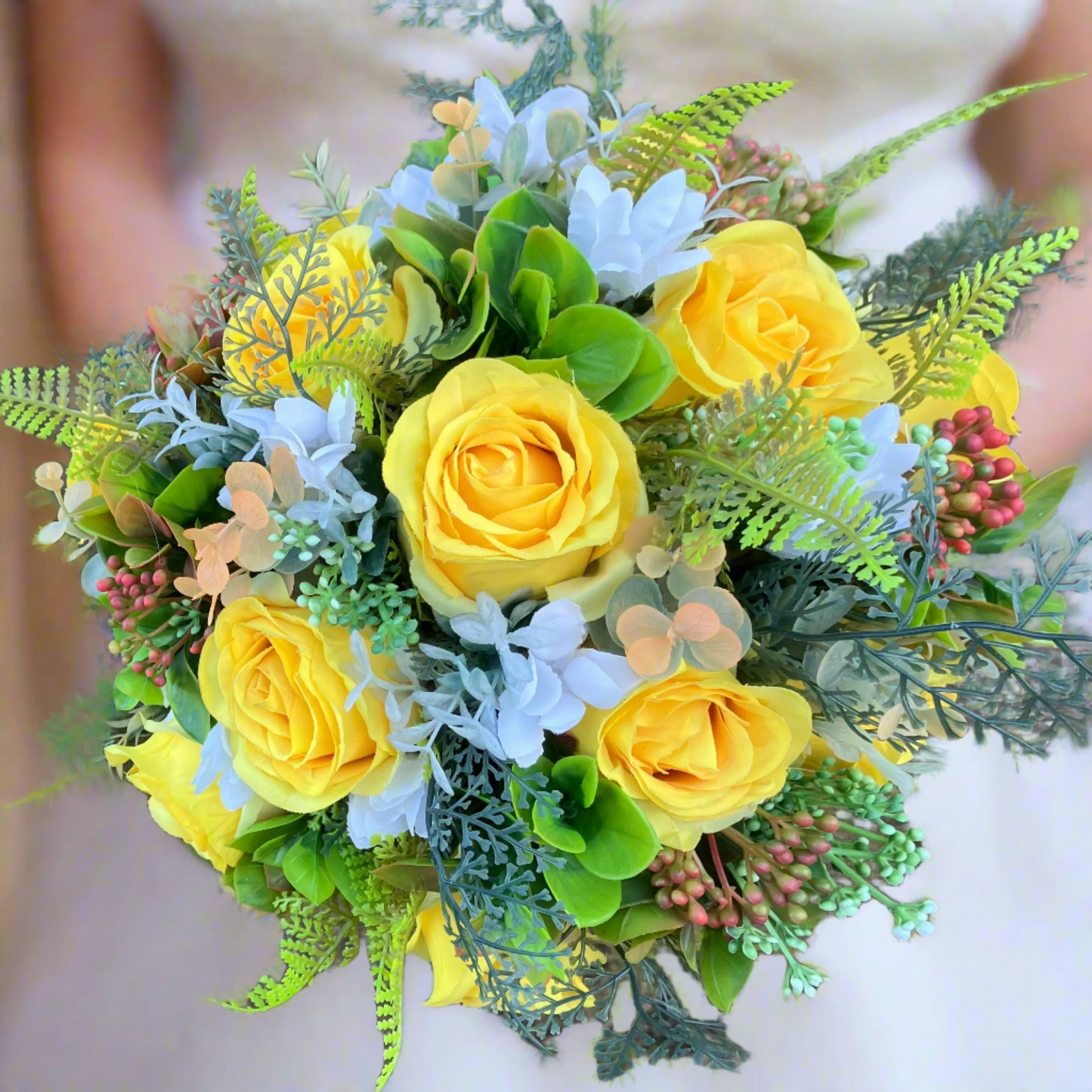 A brides bouquet of roses, peonies and fern