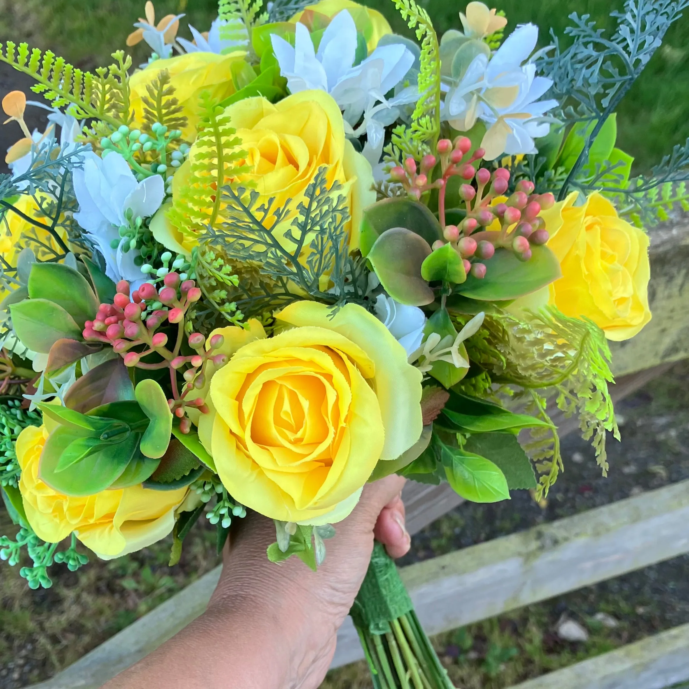 A brides bouquet of roses, peonies and fern