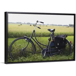 "a bike resting along a fence in the countryside" Black Float Frame Canvas Art