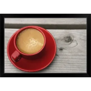 "A bright red cup of espresso coffee on a picnic table outdoors on a summer day." Black Framed Print