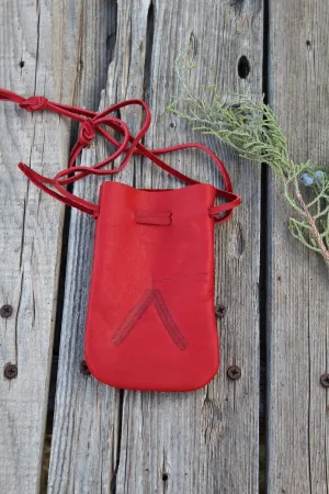 Red leather medicine bag with burned feathers